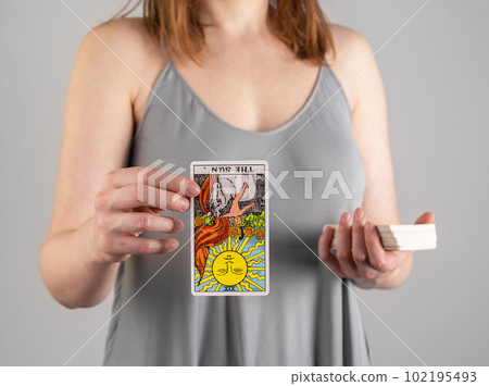 Reversed tarot card The Sun in hand fortune-teller. Divination concept 102195493