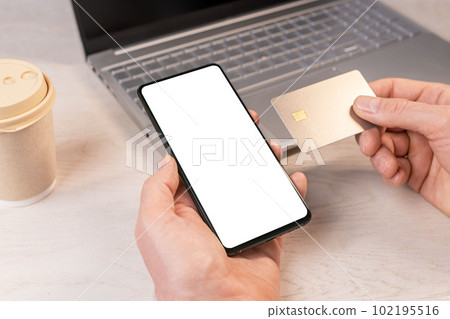 Hand holding mobile phone mockup, smartphone screen frame and credit card mock-up for paying online. Bank app ad 102195516