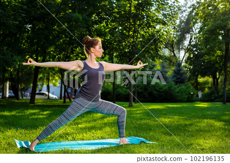 Young woman doing yoga exercises in the summer city park. Young woman doing yoga exercises in the summer city park. 102196135