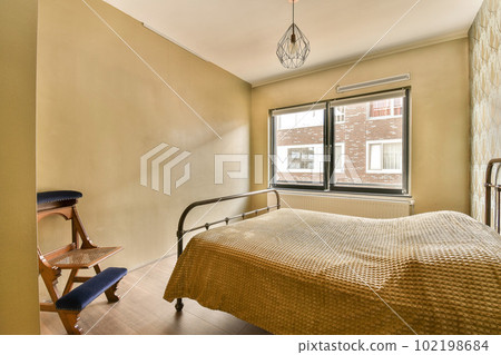 a bedroom with a bed, chair and window looking out onto the street in front of the apartment's windows a bedroom with a bed, chair and window looking out onto the street in front of the apartment's windows 102198684