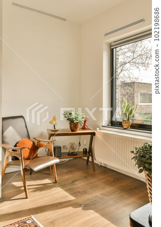 a living room with some plants in the window sies and an old chair on the floor next to it a living room with some plants in the window sies and an old chair on the floor next to it 102198686