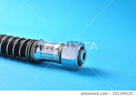 brake hose with a protective sheath for a truck, car accessories, auto parts, car brake system parts on a blue background brake hose with a protective sheath for a truck, car accessories, auto parts, car brake system parts on a blue background 102199220