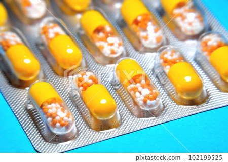 capsules in a blister, a medicine, tablets, vitamins in the form of granules in a yellow capsule, blur as a creative technique of the author capsules in a blister, a medicine, tablets, vitamins in the form of granules in a yellow capsule, blur as a creative technique of the author 102199525