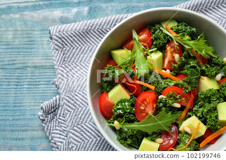 Tasty fresh kale salad on light blue wooden table, flat lay Tasty fresh kale salad on light blue wooden table, flat lay 102199746