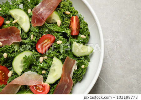 Delicious kale salad on grey table, top view 102199778
