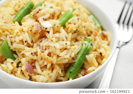 Tasty rice pilaf with vegetables on table, closeup Tasty rice pilaf with vegetables on table, closeup 102199921