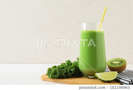 Tasty fresh kale smoothie on white wooden table. Space for text Tasty fresh kale smoothie on white wooden table. Space for text 102199963