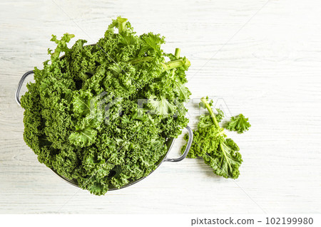 Fresh kale leaves on white wooden table, flat lay Fresh kale leaves on white wooden table, flat lay 102199980