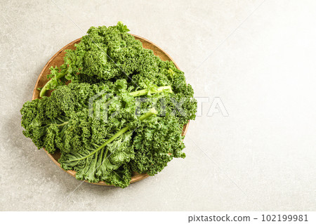 Fresh kale leaves on light grey table, top view. Space for text Fresh kale leaves on light grey table, top view. Space for text 102199981
