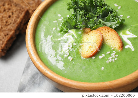 Tasty kale soup with croutons on grey marble table, closeup 102200000