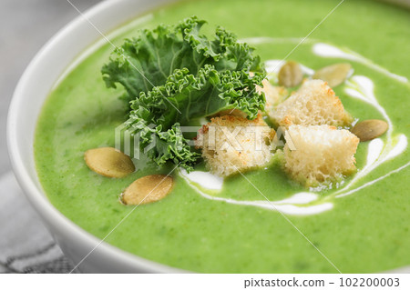 Tasty kale soup with croutons on table, closeup 102200003