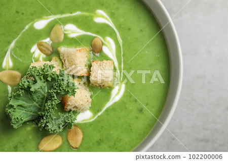 Tasty kale soup with croutons on grey table, closeup 102200006
