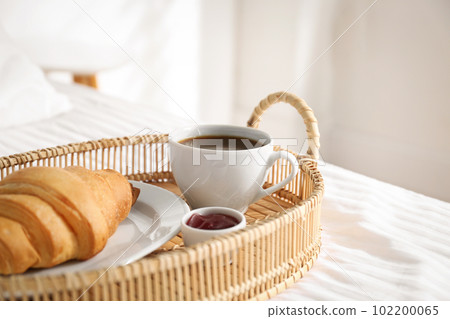 Tray with tasty breakfast on bed. Cozy morning 102200065