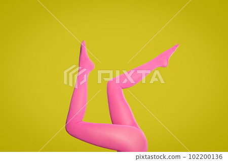 Woman wearing pink tights on yellow background, closeup of legs Woman wearing pink tights on yellow background, closeup of legs 102200136