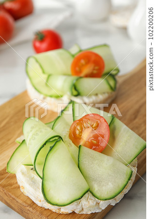Puffed rice cakes with vegetables on table, closeup Puffed rice cakes with vegetables on table, closeup 102200206