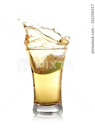 Splashing Mexican Tequila in shot glass with lime slice isolated on white Splashing Mexican Tequila in shot glass with lime slice isolated on white 102200317