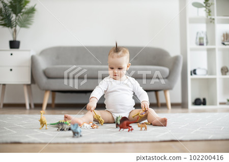 Infant child staying calm and happy while playing at home Infant child staying calm and happy while playing at home 102200416