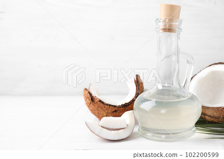 Coconut oil on white wooden table. Space for text 102200599