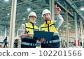 Two factory specialists are smiling while making plans 102201566