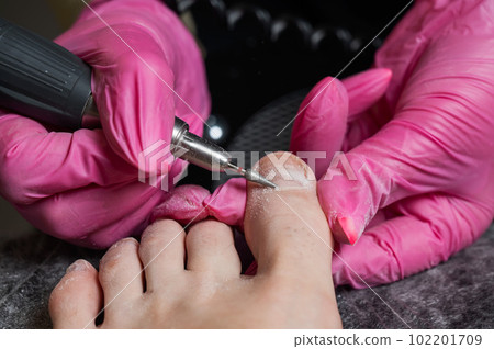 The master makes hardware pedicures to the client. Cuticle treatment.  102201709