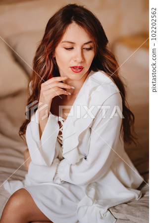 portrait of a beautiful woman in a white sexy dress with lacing and ruffles portrait of a beautiful woman in a white sexy dress with lacing and ruffles 102202562