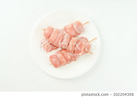 Skewers from raw chicken leg meat without skin on a white plate for a supermarket on a white background.Food for retail.Chicken skewers.Chicken meat.Procurement for designers. 102204308