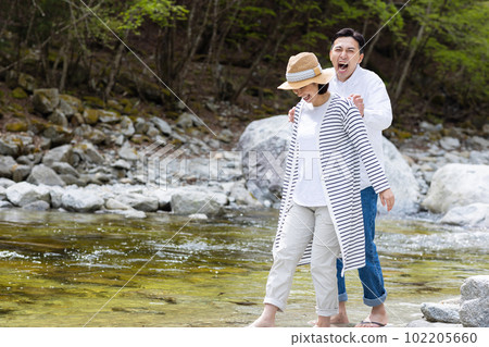 A couple enjoying playing in the river 102205660