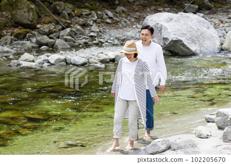 A couple enjoying playing in the river 102205670