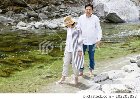 A couple enjoying playing in the river 102205858