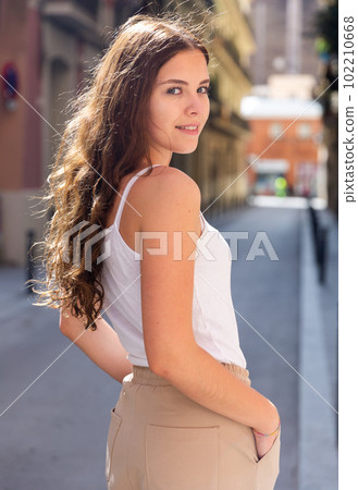 Cheerful attractive female walking on street outdoor Cheerful attractive female walking on street outdoor 102210668