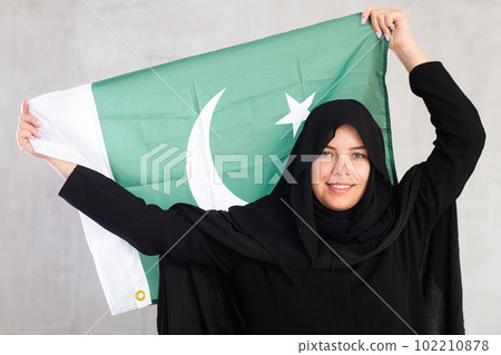 Happy young woman dressed in traditional islamic clothes with pakistani flag 102210878