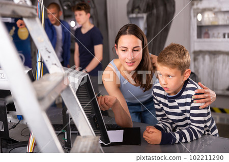 Portrait of a mother and son in front of a computer in the quest room Portrait of a mother and son in front of a computer in the quest room 102211290