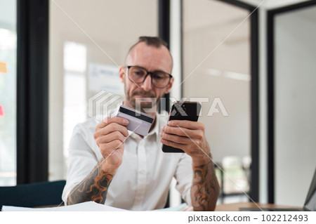 Man using mobile smart phone and credit card making online payment with mobile phone. Online shopping concept 102212493
