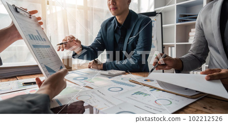 Business team presents and explains and using tablet discuss marketing numerical charts that display financial budgets, investments, project plans 102212526