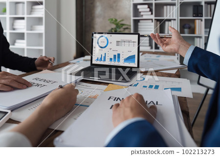 Business team discussing working analyzing with financial data and marketing growth report graph in team, presentation on laptop in office Business team discussing working analyzing with financial data and marketing growth report graph in team, presentation on laptop in office 102213273