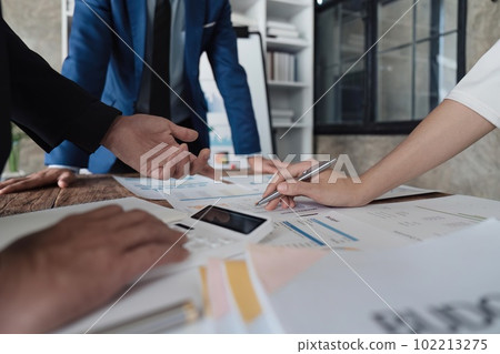 Business team using a calculator to calculate the numbers of statistic business profits growth rate on documents analyzing graph data, desk in the office Business team using a calculator to calculate the numbers of statistic business profits growth rate on documents analyzing graph data, desk in the office 102213275
