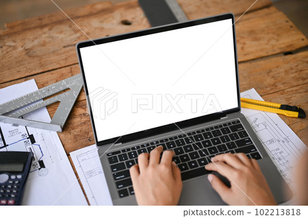 Close-up image of a professional female engineer or architect using laptop in the office. Close-up image of a professional female engineer or architect using laptop in the office. 102213818