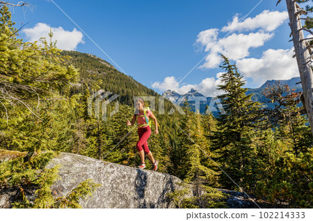 Running woman trail runner. Sport and fitness woman doing cross-country trail run ultra marathon training in mountains. Female athlete living healthy lifestyle. Squamish, British Columbia, Canada. Running woman trail runner. Sport and fitness woman doing cross-country trail run ultra marathon training in mountains. Female athlete living healthy lifestyle. Squamish, British Columbia, Canada. 102214333