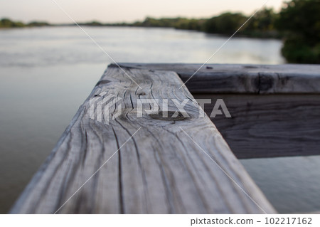 Wood bridge rail over river close up old Wood bridge rail over river close up old 102217162