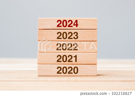 2024 block over 2023 and 2022 wooden building on table background. Business planning, Risk Management, Resolution, strategy, solution, goal, New Year New You and happy holiday concepts 102218827