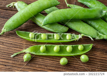 Fresh pea pods on a wooden background 102221724