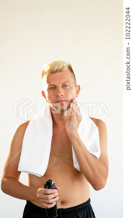 Male shaving. Skincare routine. Attractive shirtless blond guy holding shaving foam touching clean face isolated on white copy space background. Male shaving. Skincare routine. Attractive shirtless blond guy holding shaving foam touching clean face isolated on white copy space background. 102222044
