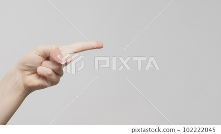 Pointing gesture. Hand indication. Woman showing finger on copy space on light gray background. Pointing gesture. Hand indication. Woman showing finger on copy space on light gray background. 102222045