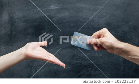 Family finances. Bank operation. Wife hand asking husband to give credit card on blackboard. Family finances. Bank operation. Wife hand asking husband to give credit card on blackboard. 102222137
