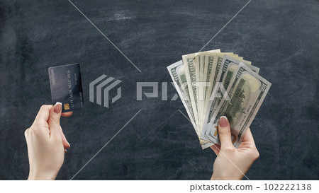 Money gestures. Cashless transfer. Woman hand holding comparing credit card dollar fan on black chalkboard. Money gestures. Cashless transfer. Woman hand holding comparing credit card dollar fan on black chalkboard. 102222138