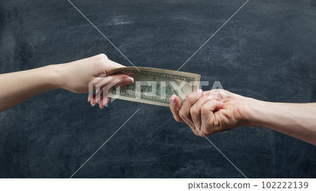Money gestures. Family finances. Husband hand giving to wife salary in dollars on black chalkboard. Money gestures. Family finances. Husband hand giving to wife salary in dollars on black chalkboard. 102222139