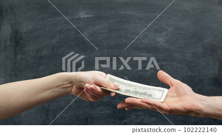 Money loan. Financial support. Man and woman hands holding dollars on chalkboard background. 102222140