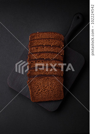 Delicious fresh brown bread with grains and seeds sliced on a wooden cutting board Delicious fresh brown bread with grains and seeds sliced on a wooden cutting board 102224542