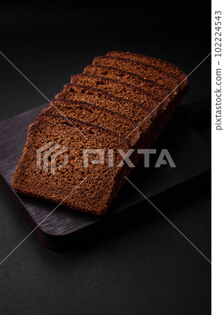 Delicious fresh brown bread with grains and seeds sliced on a wooden cutting board Delicious fresh brown bread with grains and seeds sliced on a wooden cutting board 102224543