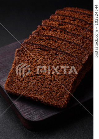 Delicious fresh brown bread with grains and seeds sliced on a wooden cutting board Delicious fresh brown bread with grains and seeds sliced on a wooden cutting board 102224544